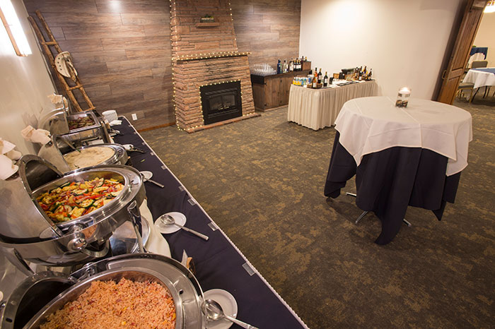 A buffet-style dining area with a fireplace, tables, and food