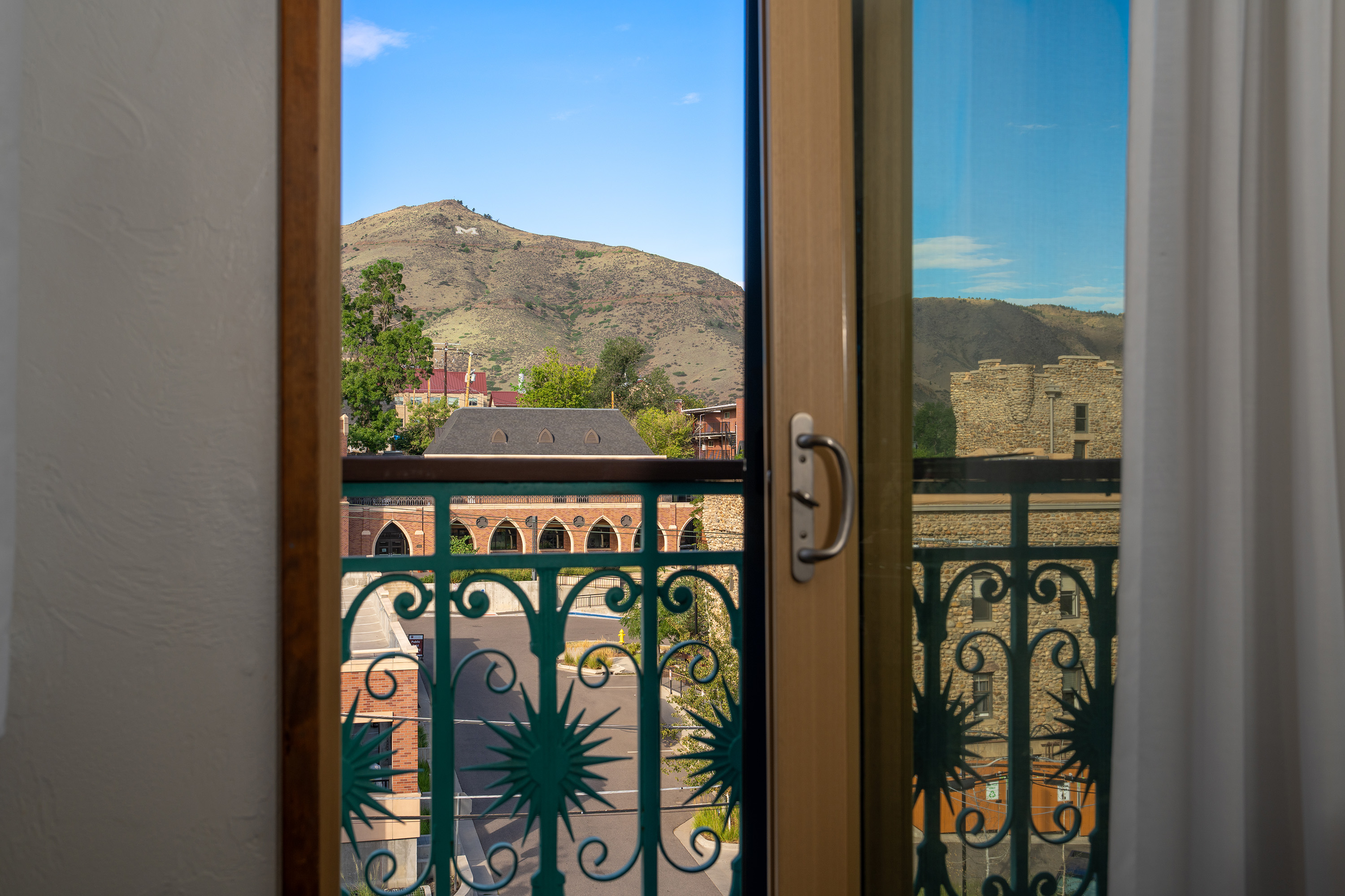 A view of a mountain from a balcony with a green railing.