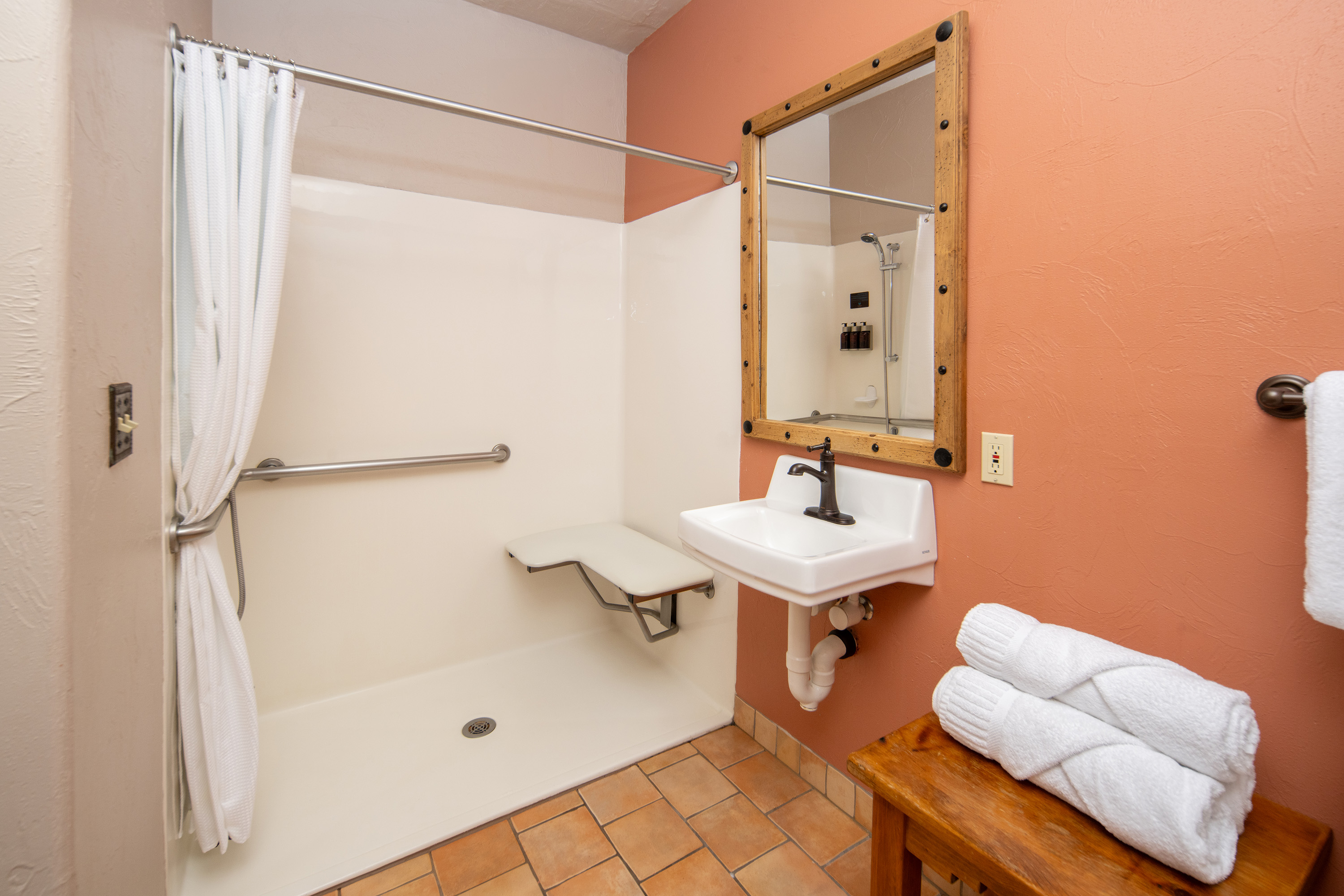 A clean and well-appointed bathroom with a shower, sink, and mirror.
